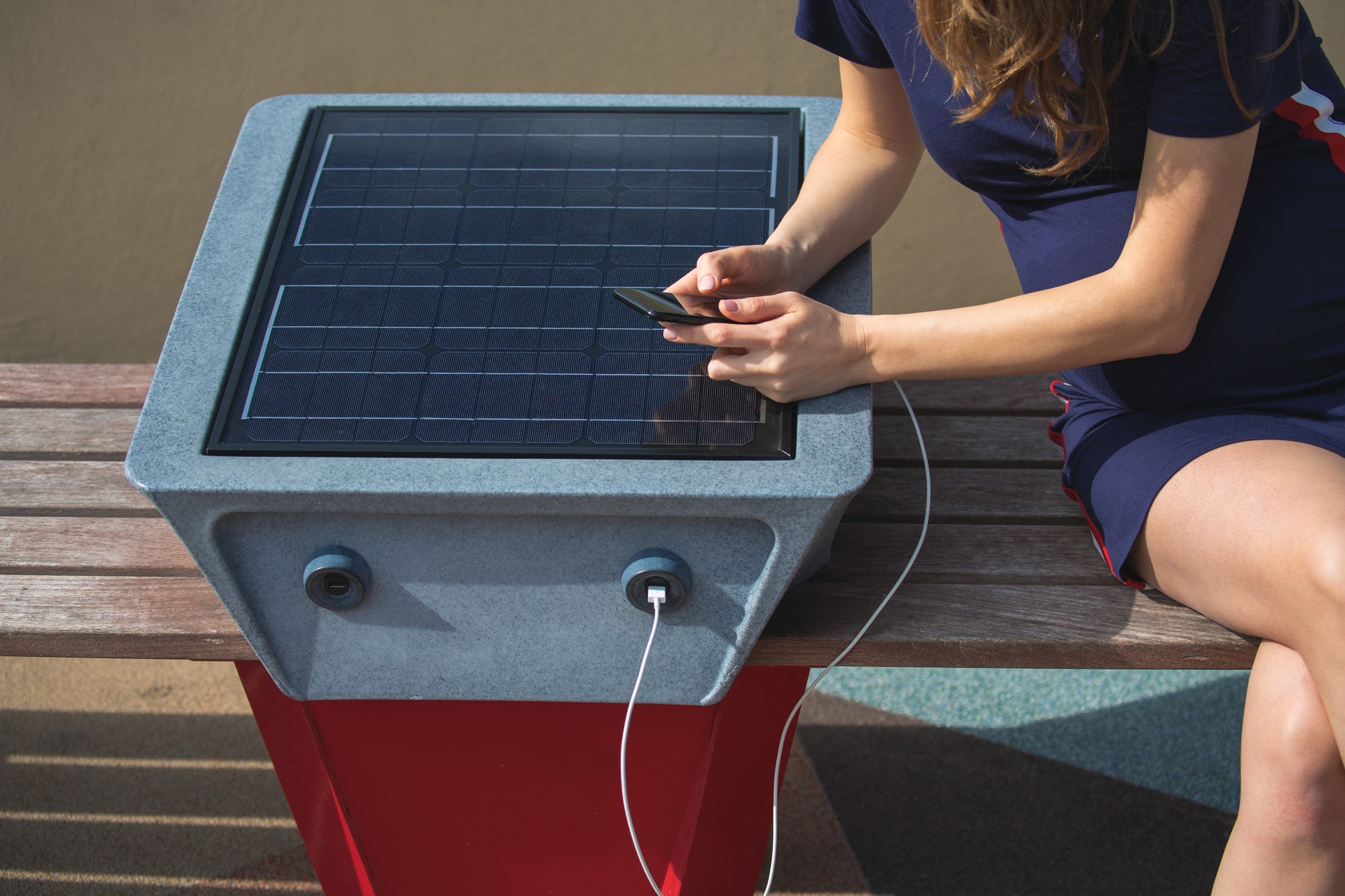 woman charging mobile phone via usb outdoors